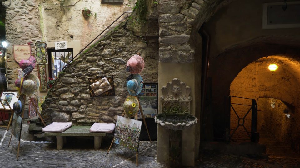Narrow alley of old city with tourist goods. Action. Meager open shop with souvenirs located in nook
